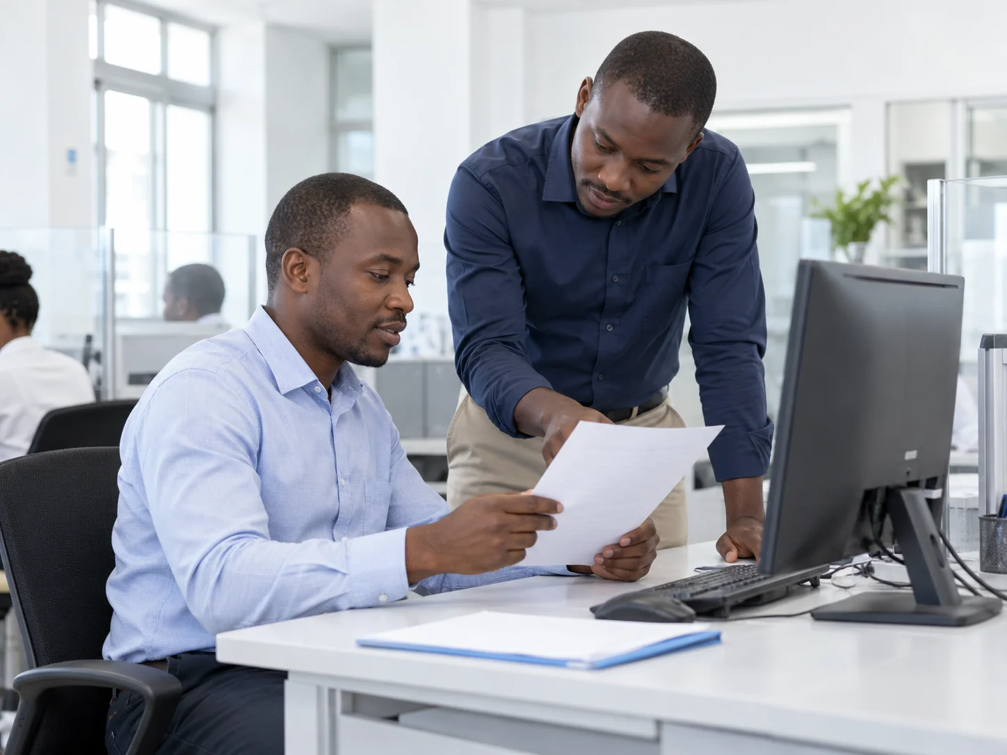 Illustration : deux professionnels ivoiriens examinant un document dans un espace de services